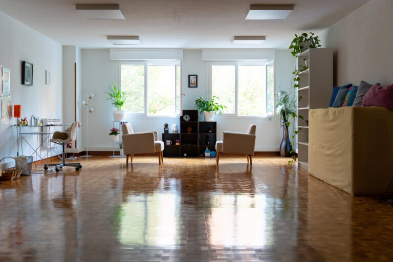 La sala de Argos con dos sillones, plantas y las ventanas al jardín